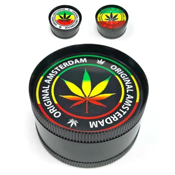 Grinder negro Rasta Leaf con hoja verde, amarilla y roja y texto «Original Amsterdam», acompañado de dos vistas pequeñas con tapas distintas.