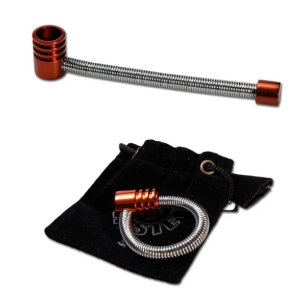 Pipa Twister Spring con tubo plateado en espiral y extremos cobrizos, mostrada estirada y enrollada sobre una bolsa negra.