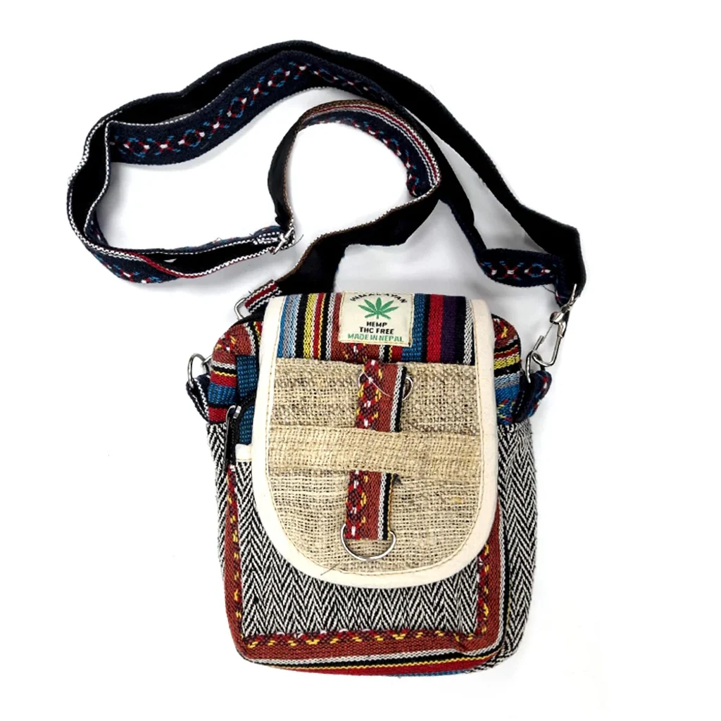 Bolso de cáñamo Nepal multicolor con solapa beige, tejido de espiga en blanco y negro y correa larga con motivos bordados.