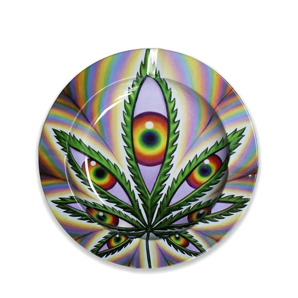 Cenicero redondo Basic Leaf Eyes con una hoja de cannabis verde cuyos foliolos contienen ojos multicolores, sobre un fondo arcoíris.