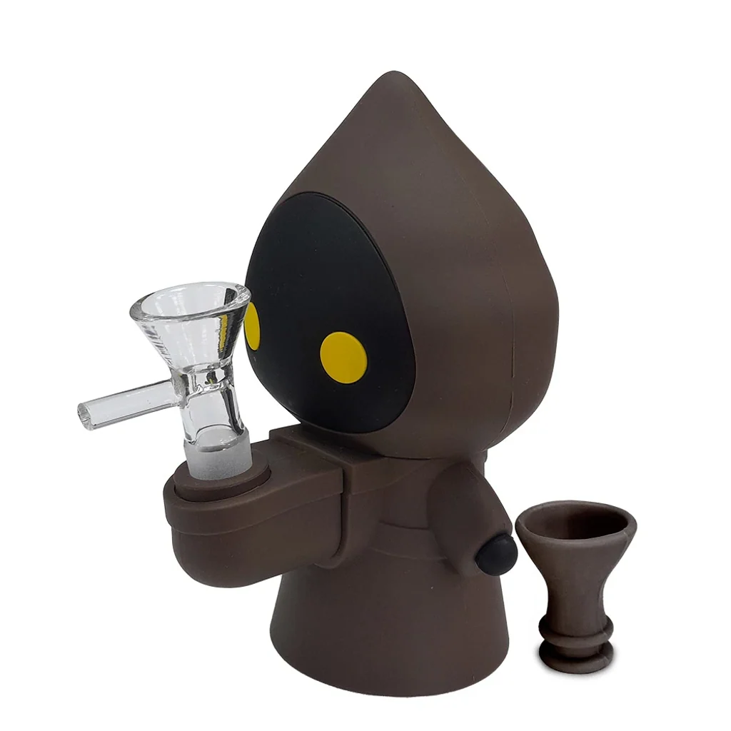 Bong Jawa con figura encapuchada marrón, rostro negro y ojos amarillos, cazoleta de vidrio y pieza marrón separada sobre fondo blanco.
