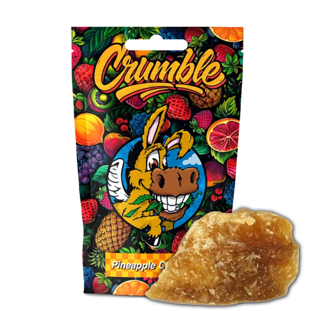 Bolsa de Crumble con frutas y un burro dibujado, junto a un fragmento dorado de superficie irregular de Flying Burrito Pineapple Crush.
