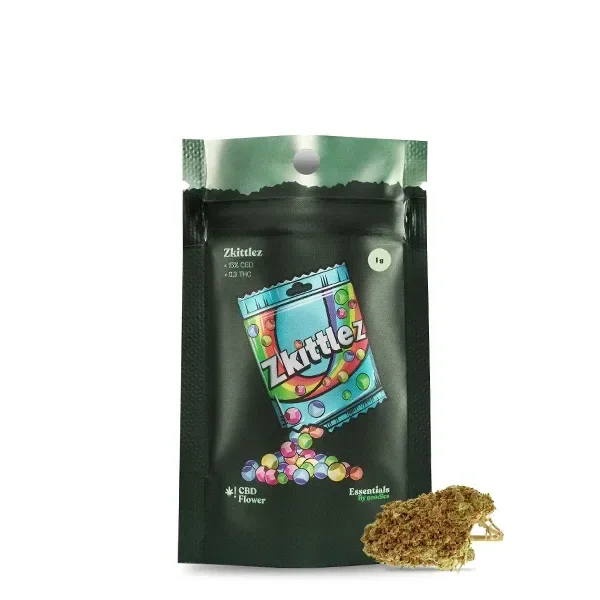 Bolsa verde oscura de CBD Goodies Zkittlez con dibujo de caramelos de colores y un cogollo colocado delante, sobre fondo blanco.