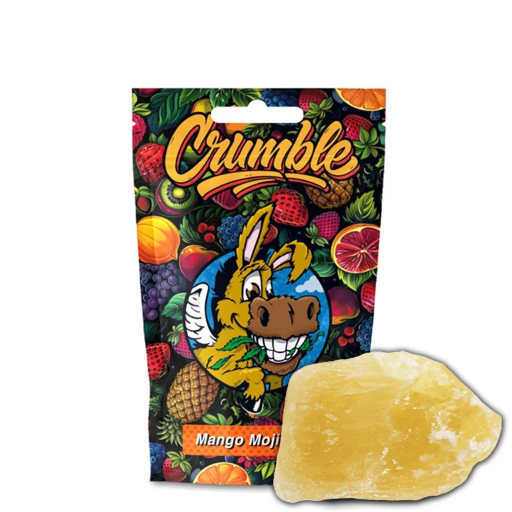Bolsa de Crumble Flying Burrito Mango Mojito con frutas y un burro ilustrado, junto a un bloque amarillo de superficie irregular.