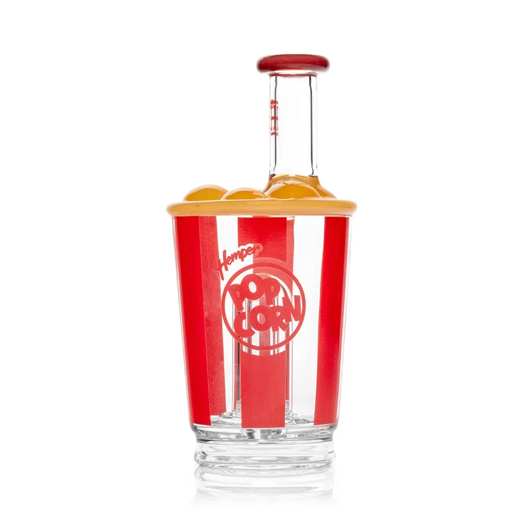 Bong Hemper Popcorn con forma de recipiente de palomitas, franjas rojas y blancas y cuello transparente con borde rojo.