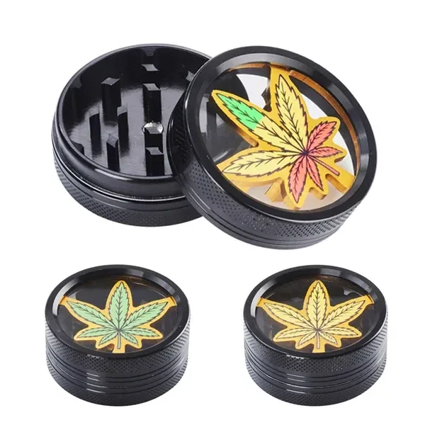 Grinders negros con tapas transparentes y hojas de cannabis en distintos colores; una vista abierta muestra los dientes interiores.