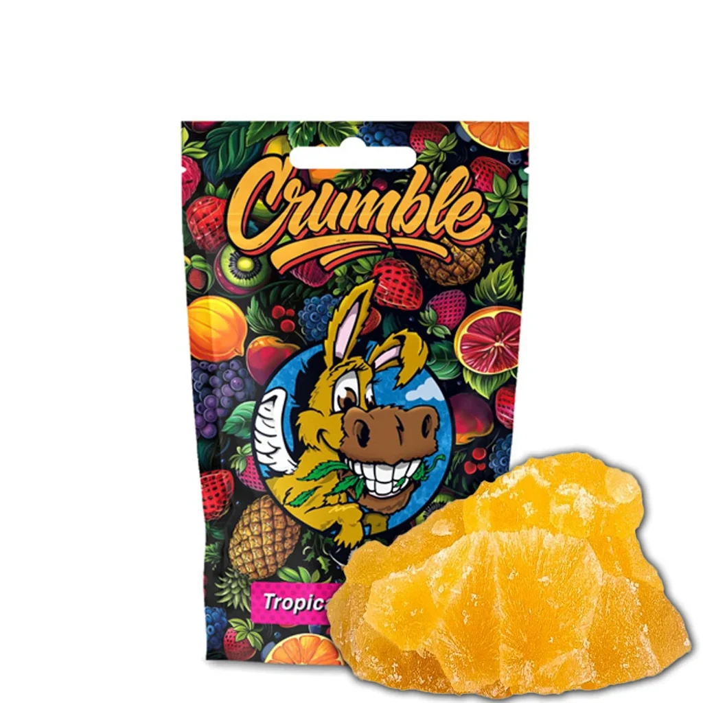 Crumble CBD Flying Burrito Tropical Peach con trozos amarillos ante una bolsa decorada con frutas y un burro de dibujos animados.