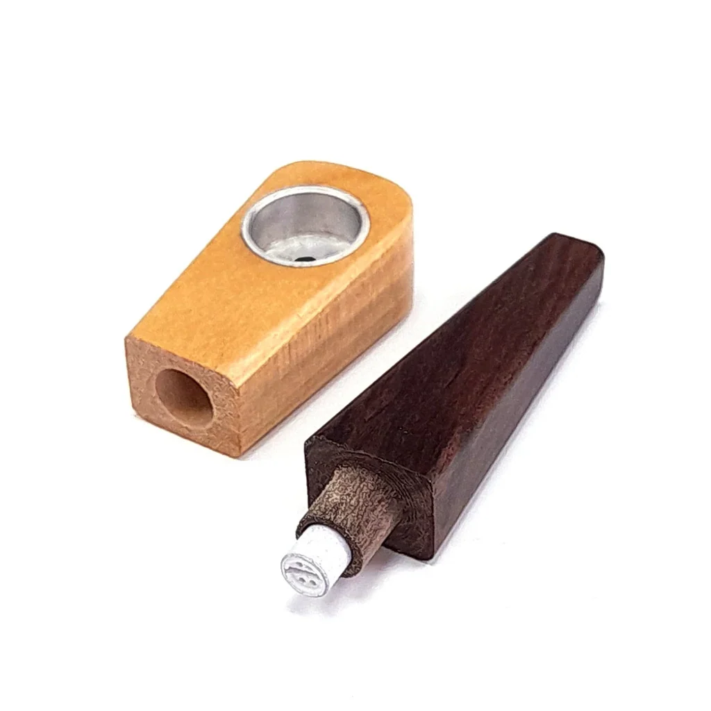Pipa de madera desmontada, con cazoleta clara de interior metálico y boquilla oscura separada que deja visible el filtro.