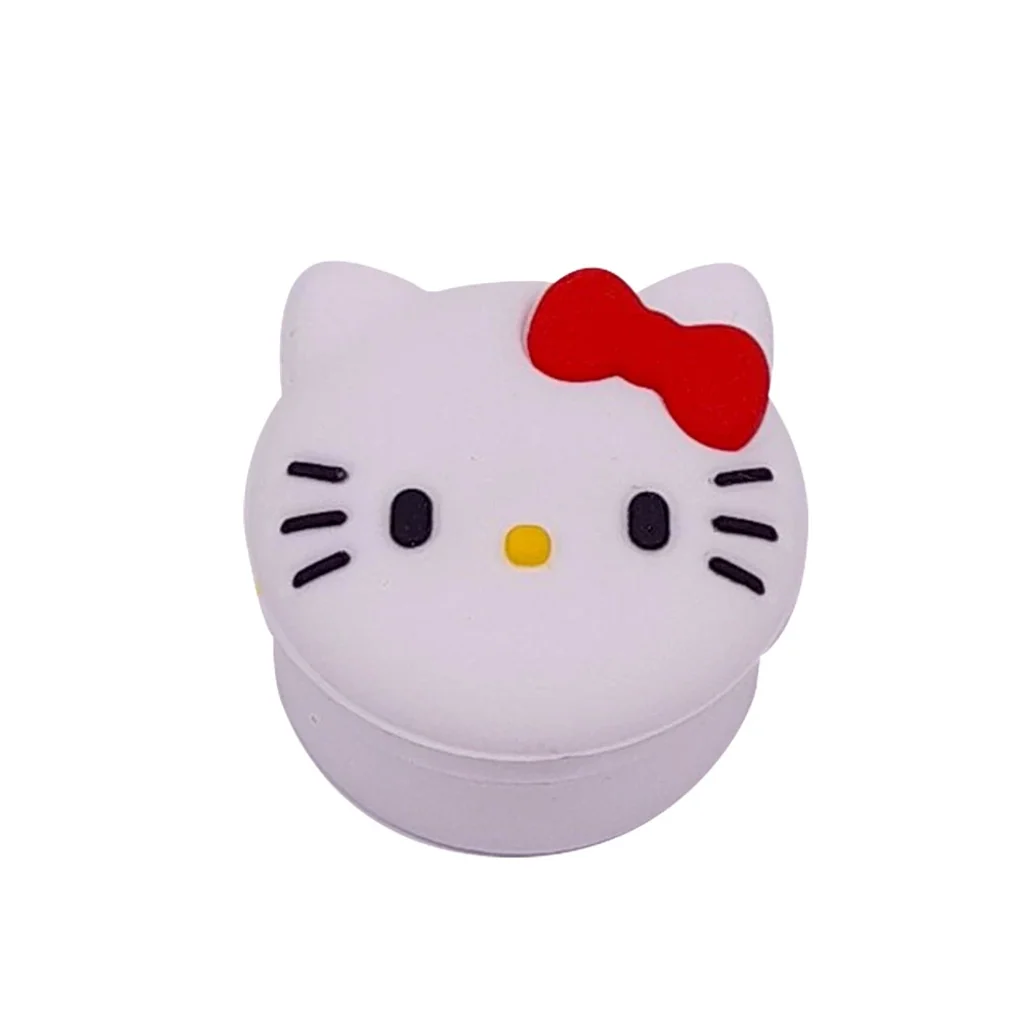 Bote de silicona Hello Kitty cerrado, con tapa en forma de cara blanca, lazo rojo, nariz amarilla y bigotes negros.