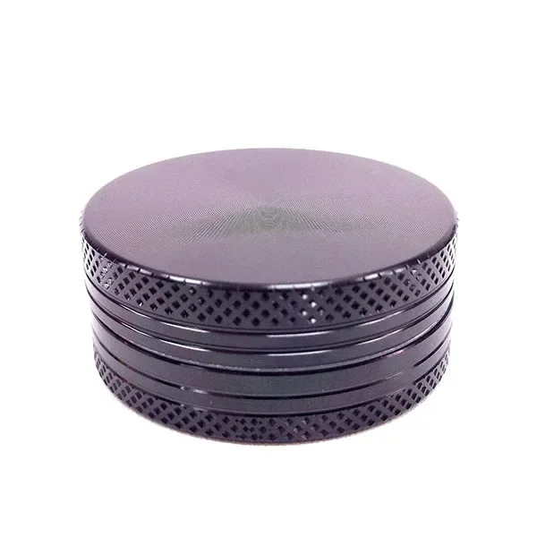 Grinder circular oscuro cerrado, visto en perspectiva, con tapa lisa, varias secciones y bordes de agarre con trama de rombos.