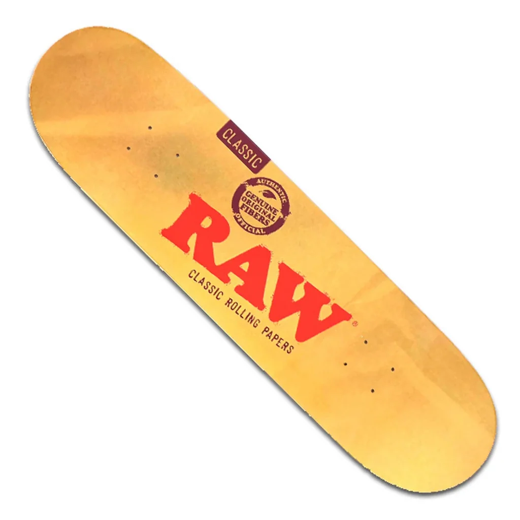 Tabla de monopatín RAW Classic en diagonal, de tono amarillo, con gran logotipo rojo, sellos oscuros y orificios de montaje sobre fondo blanco.
