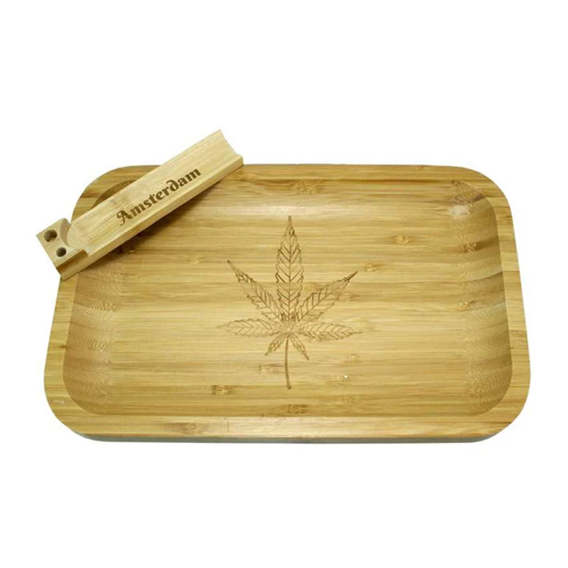 Bandeja de bambú con bordes elevados y una hoja de cannabis grabada, con un accesorio alargado que lleva la inscripción Amsterdam.