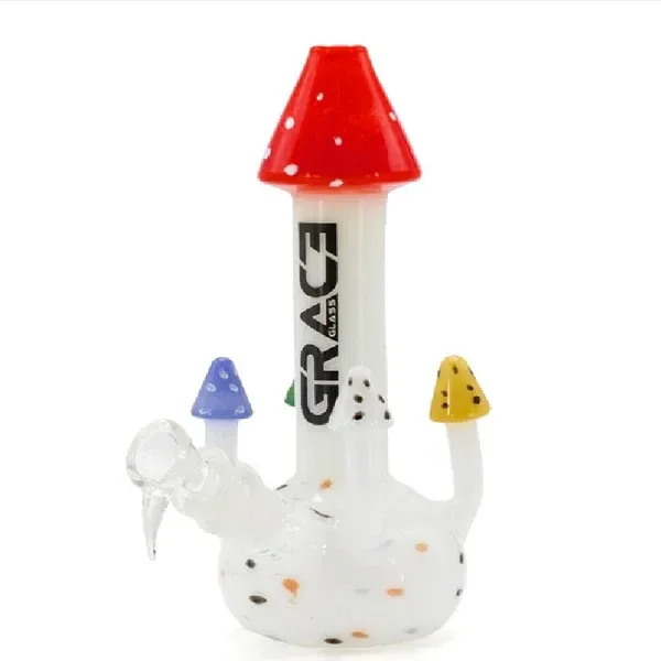 Bong blanco con boca en forma de seta roja moteada, adornos de setas de colores y conexión lateral transparente.