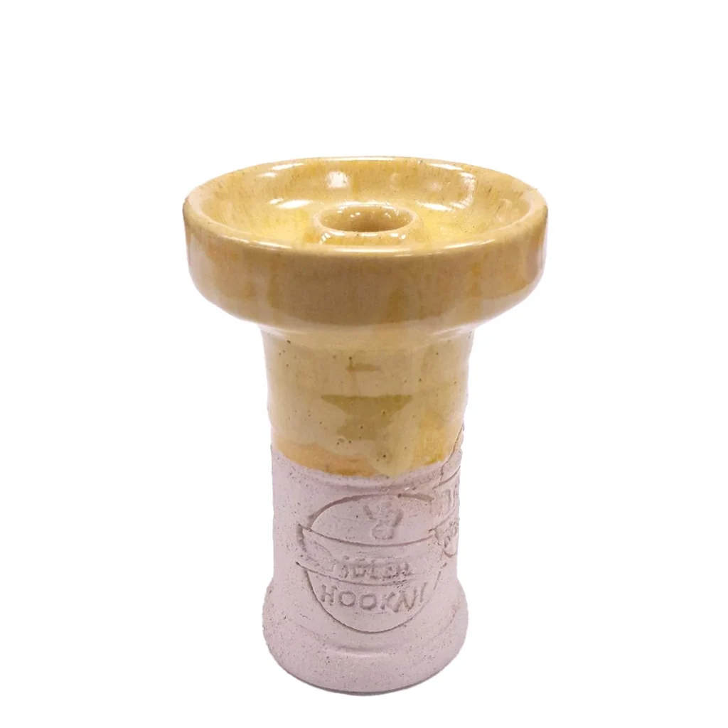 Cazoleta de shisha con plato superior amarillo ocre, orificio central elevado y base rosa pálido con un sello en relieve.