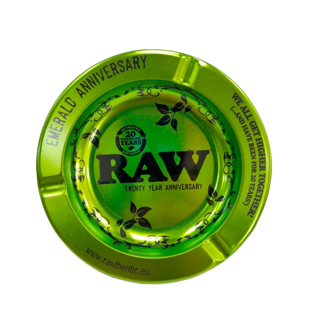 Cenicero circular RAW verde brillante, visto desde arriba, con muescas en el borde y decoración negra del vigésimo aniversario.