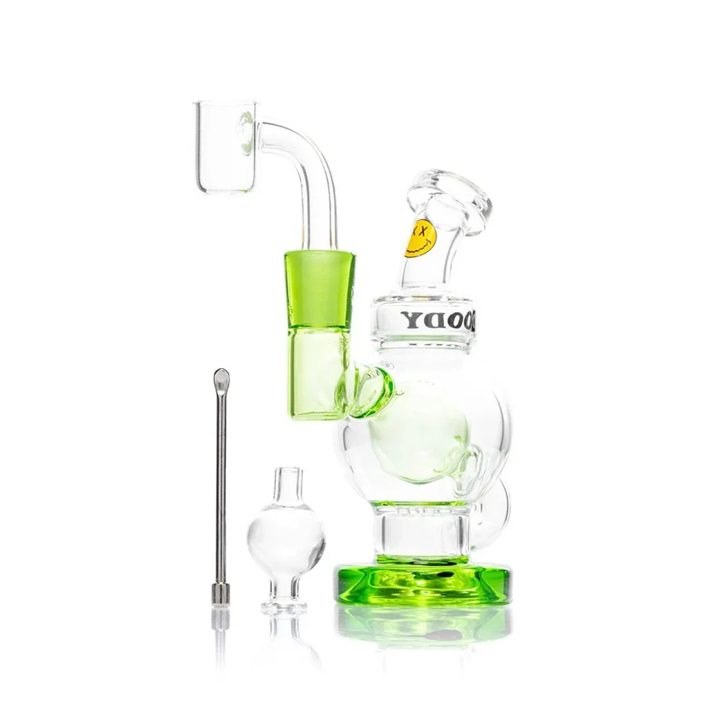 Bong de cristal transparente con base y junta verdes, cuerpo redondeado y boquilla inclinada, acompañado de accesorios.