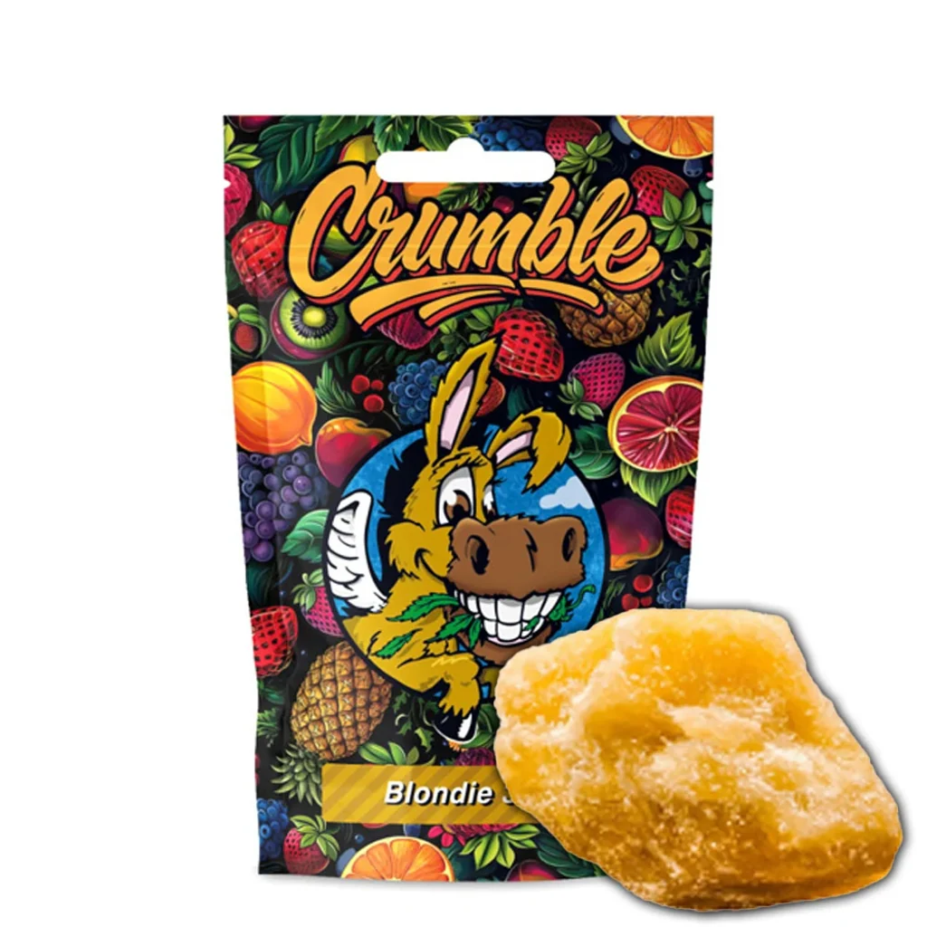 Crumble Blondie en una pieza dorada e irregular ante un envase decorado con frutas y un burro de dibujos animados.