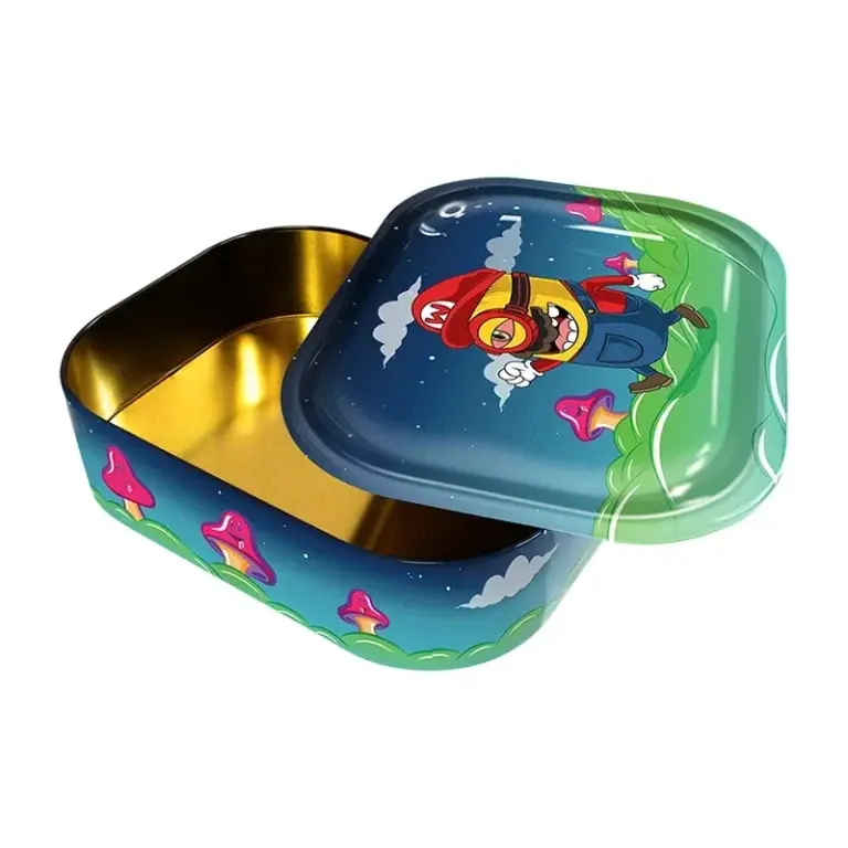 Caja metálica Mini Bros abierta, con interior dorado y tapa ladeada decorada con un personaje de dibujos, setas y paisaje verde y azul.