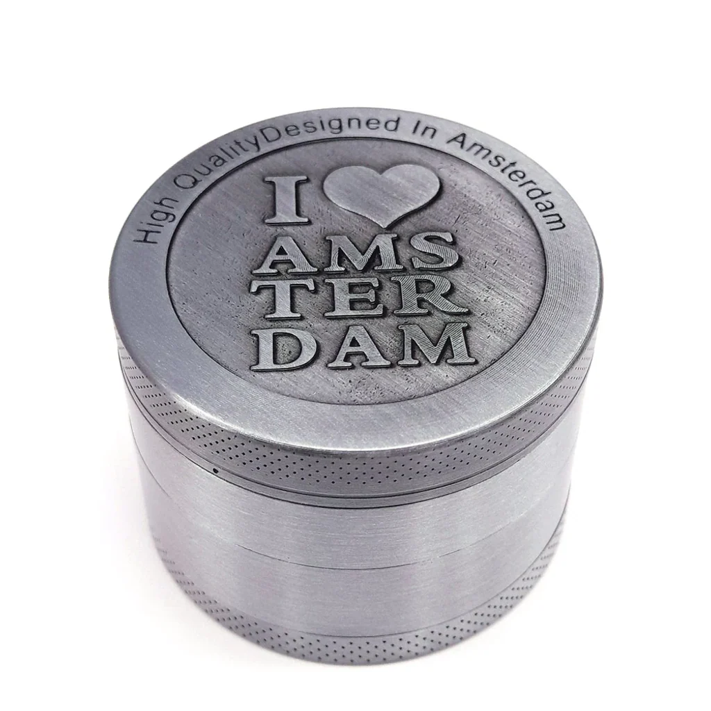 Grinder metálico I Love Amsterdam cerrado, de acabado plateado, con corazón en relieve y bordes de textura punteada.
