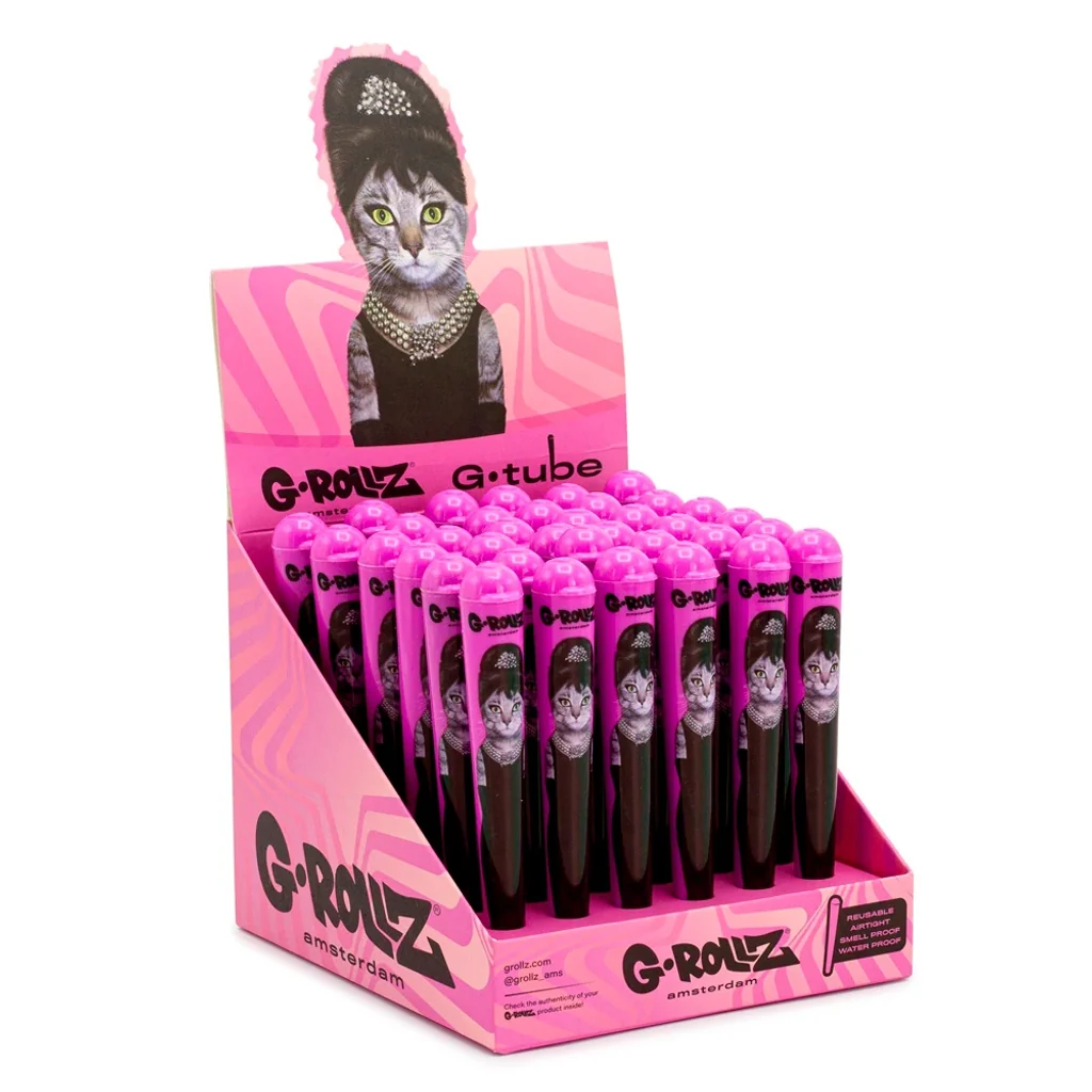 Expositor rosa de porta cigarros Amy G-Rollz con varias unidades y una gata con peinado alto, collar y vestido negro. Expositor rosa de porta cigarros Amy G-Rollz con varias unidades y una gata con peinado alto, collar y vestido negro.