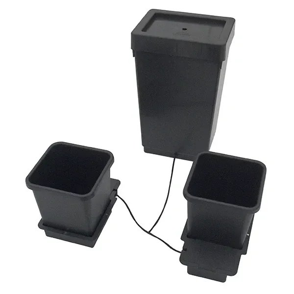 Sistema AutoPot con dos macetas cuadradas sobre bases, conectadas mediante tubos a un depósito negro con tapa, sobre fondo blanco.