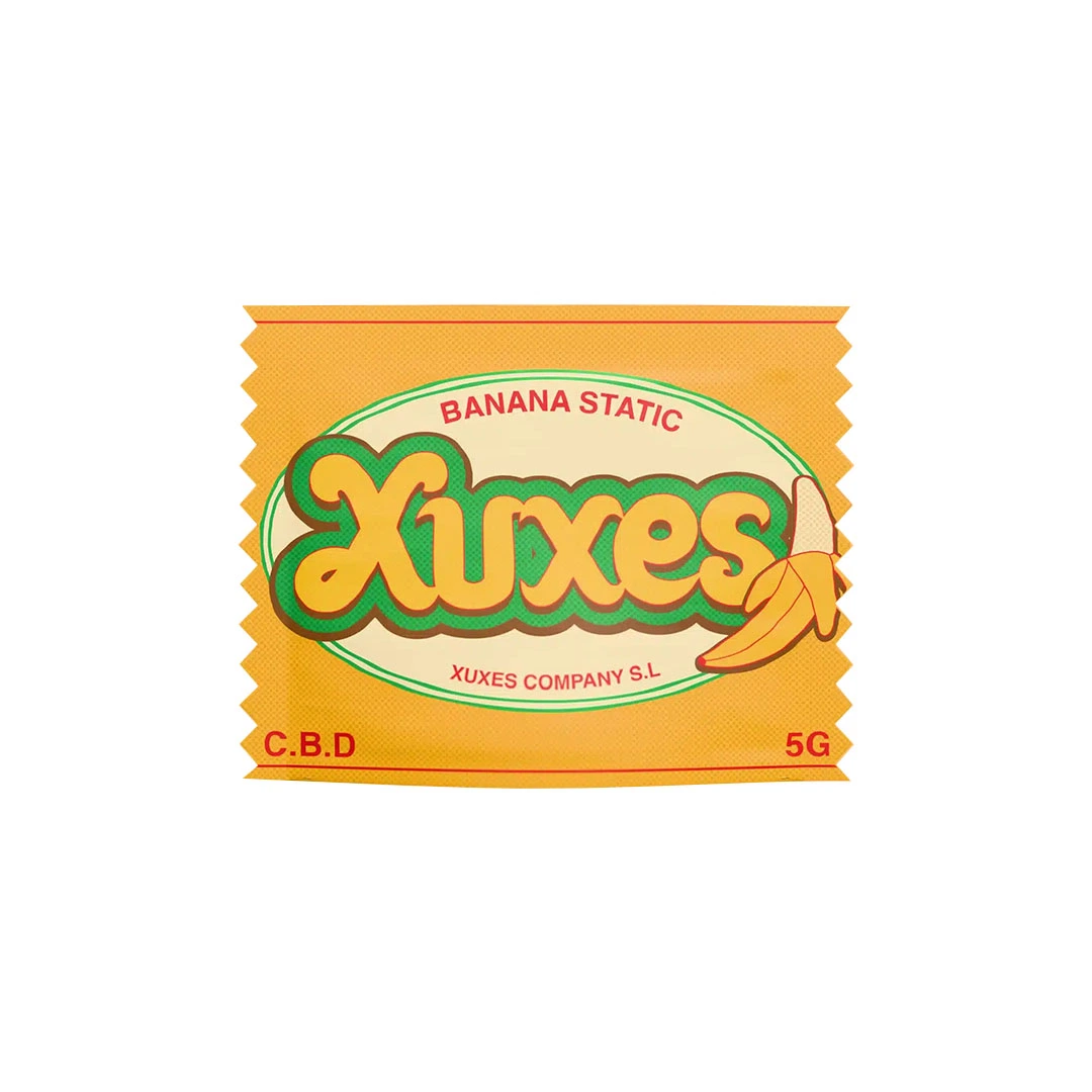 Envase amarillo de Hash CBD Banana Static Xuxes con logotipo verde y naranja, dibujo de un plátano y etiqueta de 5 g.