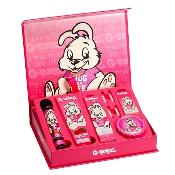 Caja regalo G-Rollz Thug for Life abierta, rosa y decorada con un conejo, con accesorios en compartimentos y un recipiente redondo. Caja regalo G-Rollz Thug for Life abierta, rosa y decorada con un conejo, con accesorios en compartimentos y un recipiente redondo.