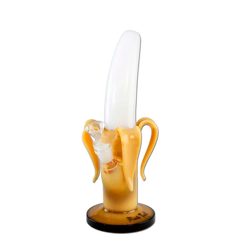 Bong de cristal con forma de plátano pelado, tubo blanco curvado, cáscara amarilla, cazoleta transparente lateral y base circular.