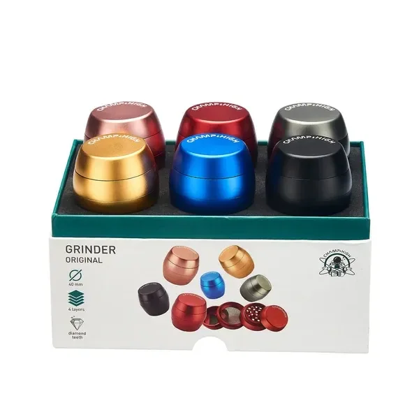 Expositor de grinders Champ con forma de barril en varios colores y un despiece ilustrado en el frontal de la caja.
