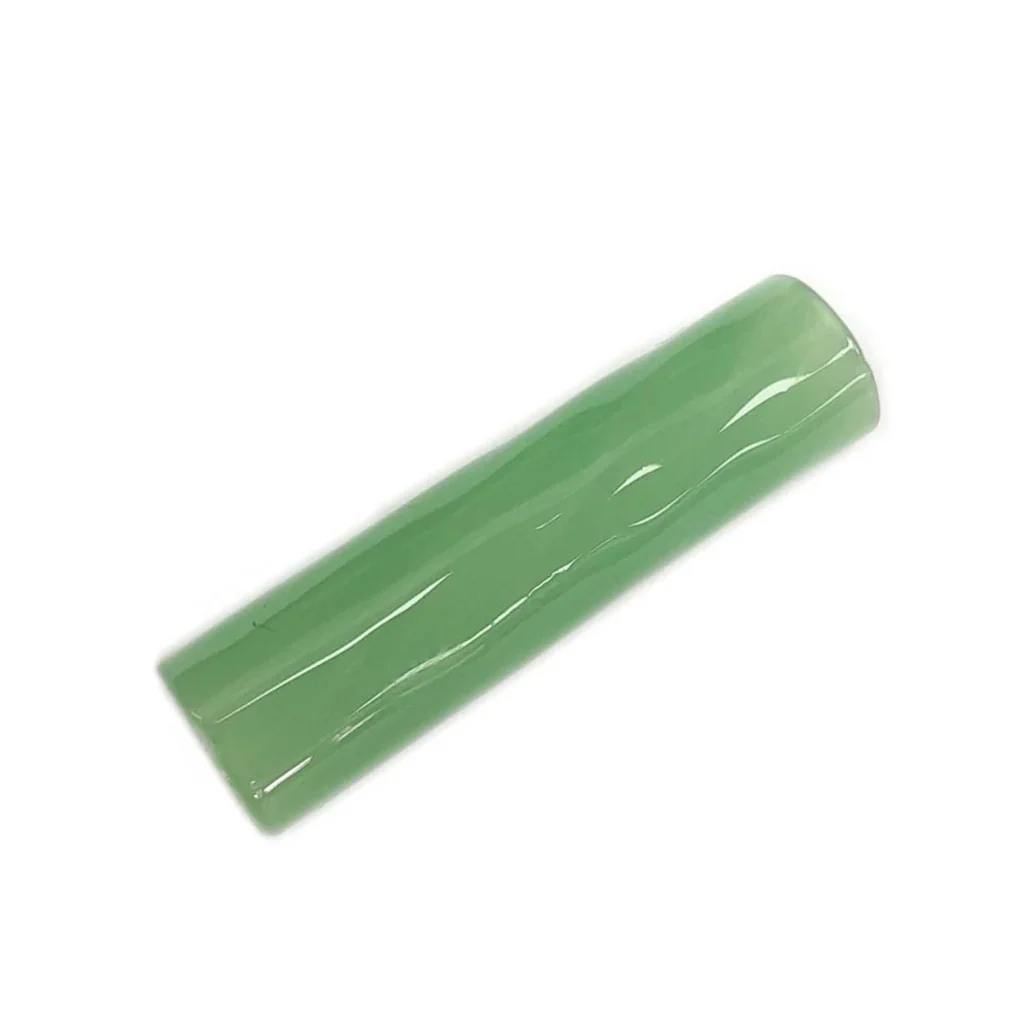 Filtro Cristal 7 Hole Emerald verde translúcido, de forma tubular y superficie brillante, dispuesto en diagonal sobre fondo blanco.