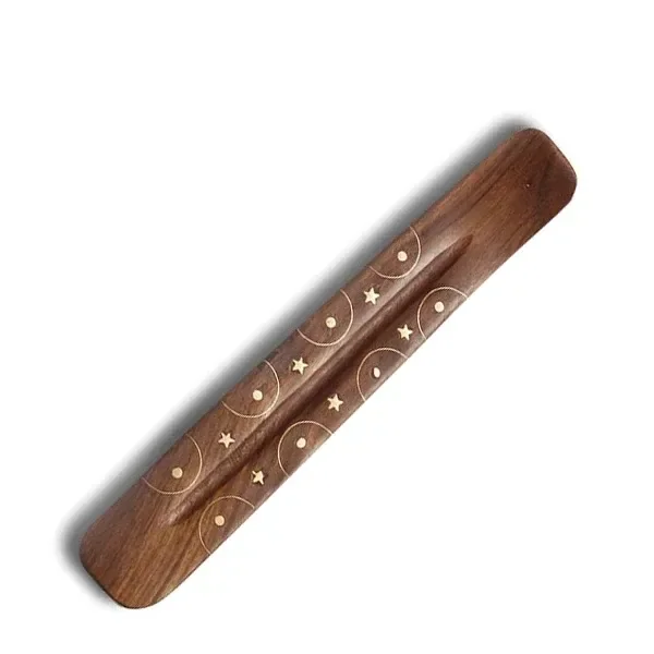 Portaincienso de madera marrón con canal central e incrustaciones de latón en forma de estrellas, círculos y puntos. Portaincienso de madera marrón con canal central e incrustaciones de latón en forma de estrellas, círculos y puntos.