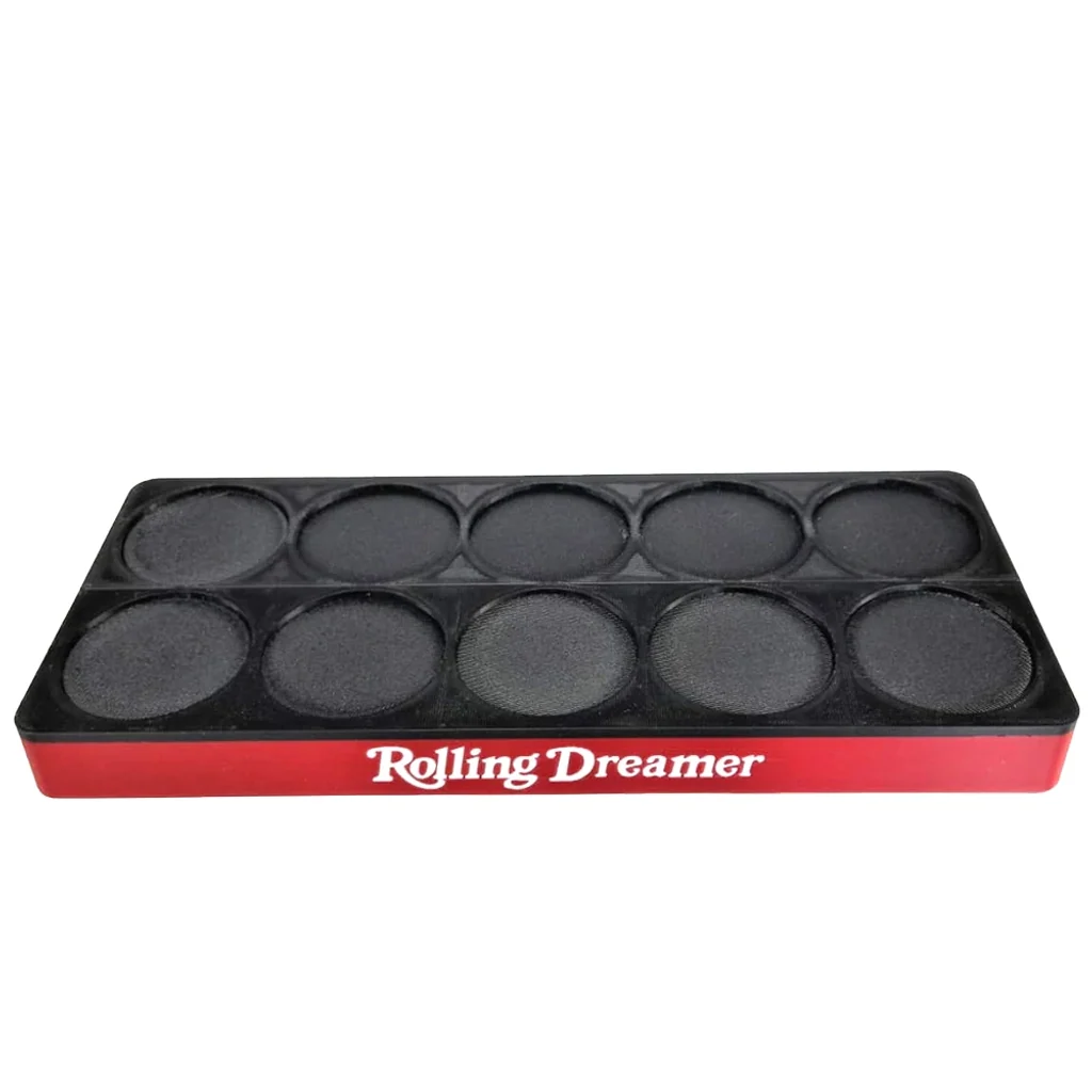 Expositor rectangular Rolling Dreamer con superficie negra, huecos circulares en dos filas y frontal rojo con el nombre en blanco.