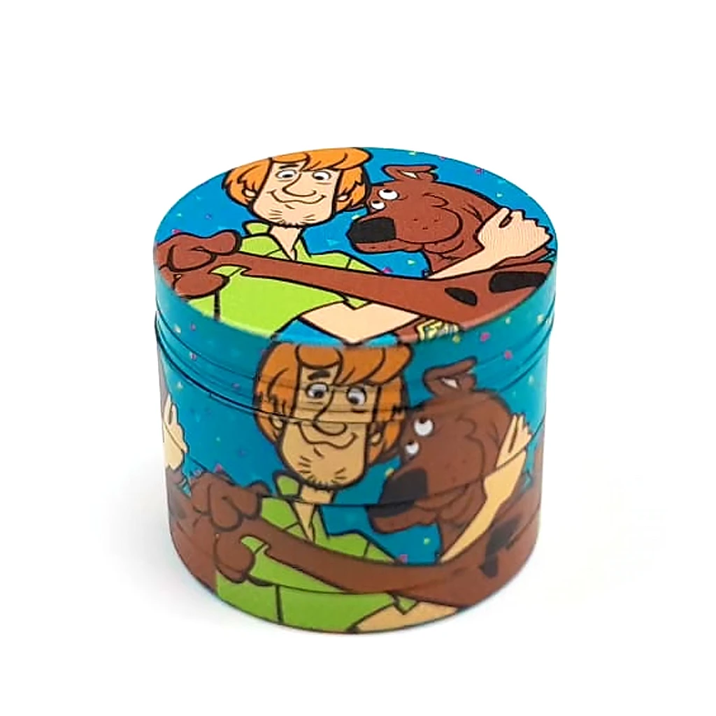 Grinder cilíndrico turquesa con ilustraciones de Scooby-Doo y Shaggy abrazados en la tapa y los laterales, sobre fondo blanco.