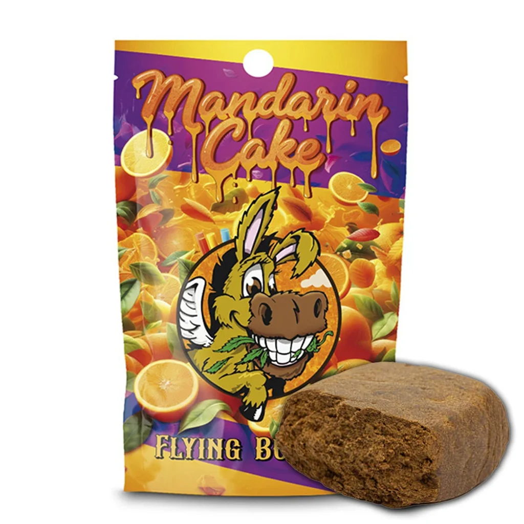Bloque marrón de hachís Mandarine Cake con un extremo abierto, delante de una bolsa con cítricos y un burro ilustrado.