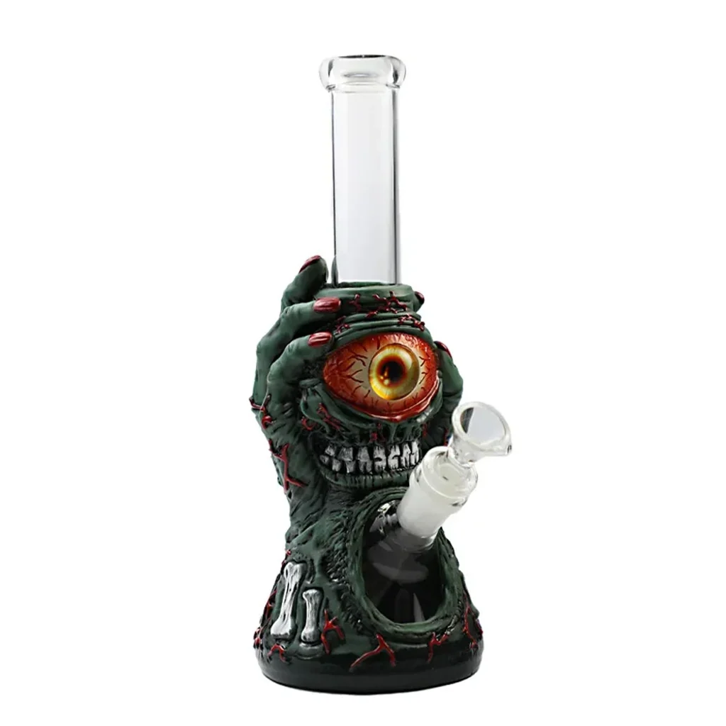 Bong Zombie Hand con tubo transparente y cuerpo de mano verde con uñas rojas, un gran ojo y dientes; cazoleta lateral inclinada.
