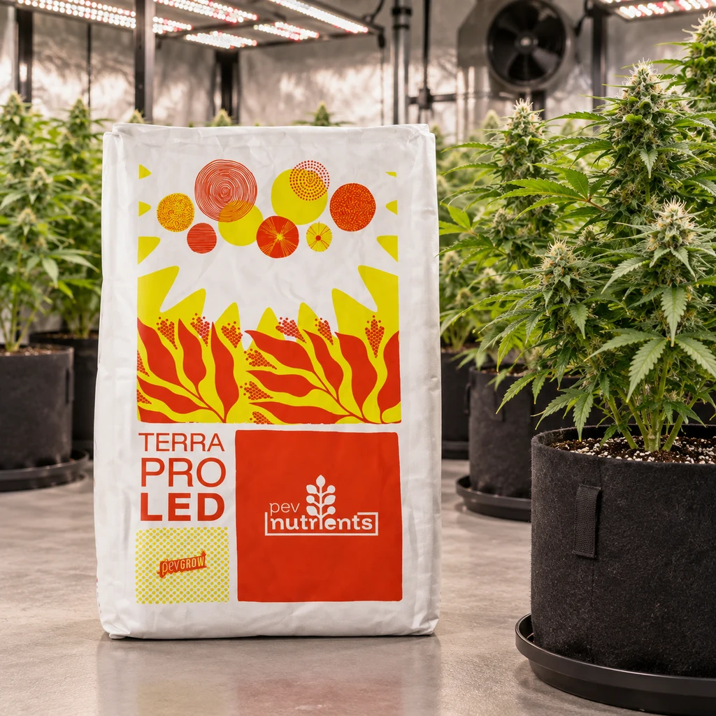 Saco de TERRA PRO LED Pev Nutrients con diseño blanco, rojo y amarillo, junto a plantas de cannabis bajo paneles LED.
