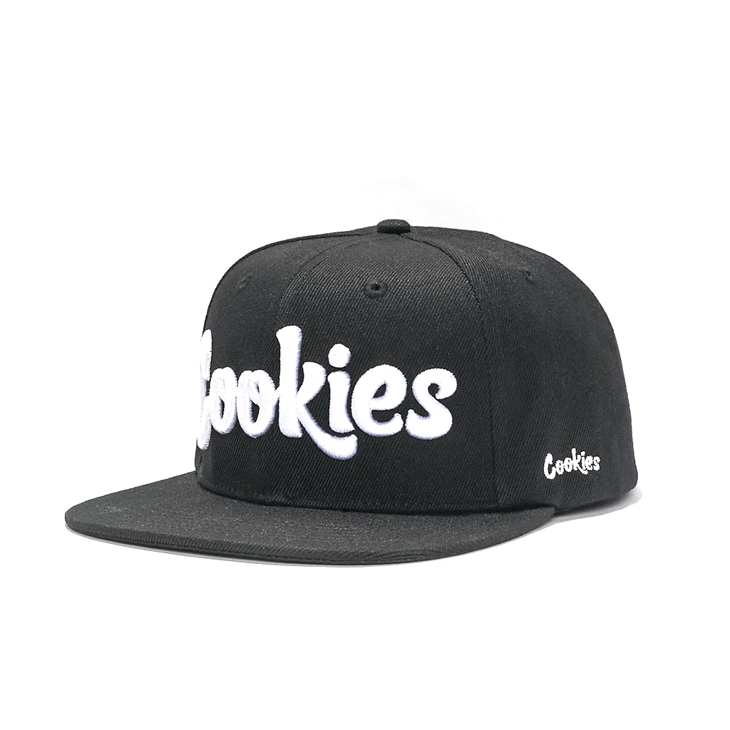 Gorra Cookies negra de visera plana, vista en tres cuartos, con logotipo blanco grande en el frontal y pequeño en el lateral.