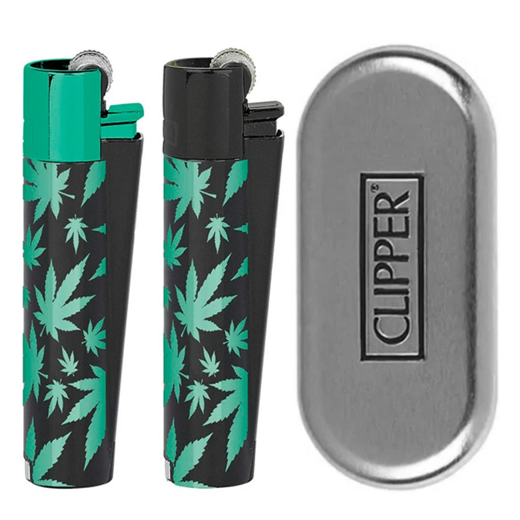 Dos encendedores Clipper negros con hojas verdes y partes superiores verde y negra, junto a un estuche plateado con el logotipo.
