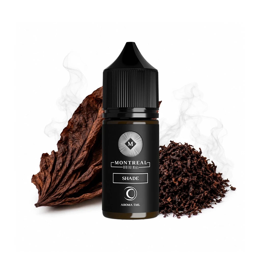 Frasco Montreal Original Shade de 5 ml con tapón negro, junto a una hoja seca y tabaco picado, con volutas claras al fondo.