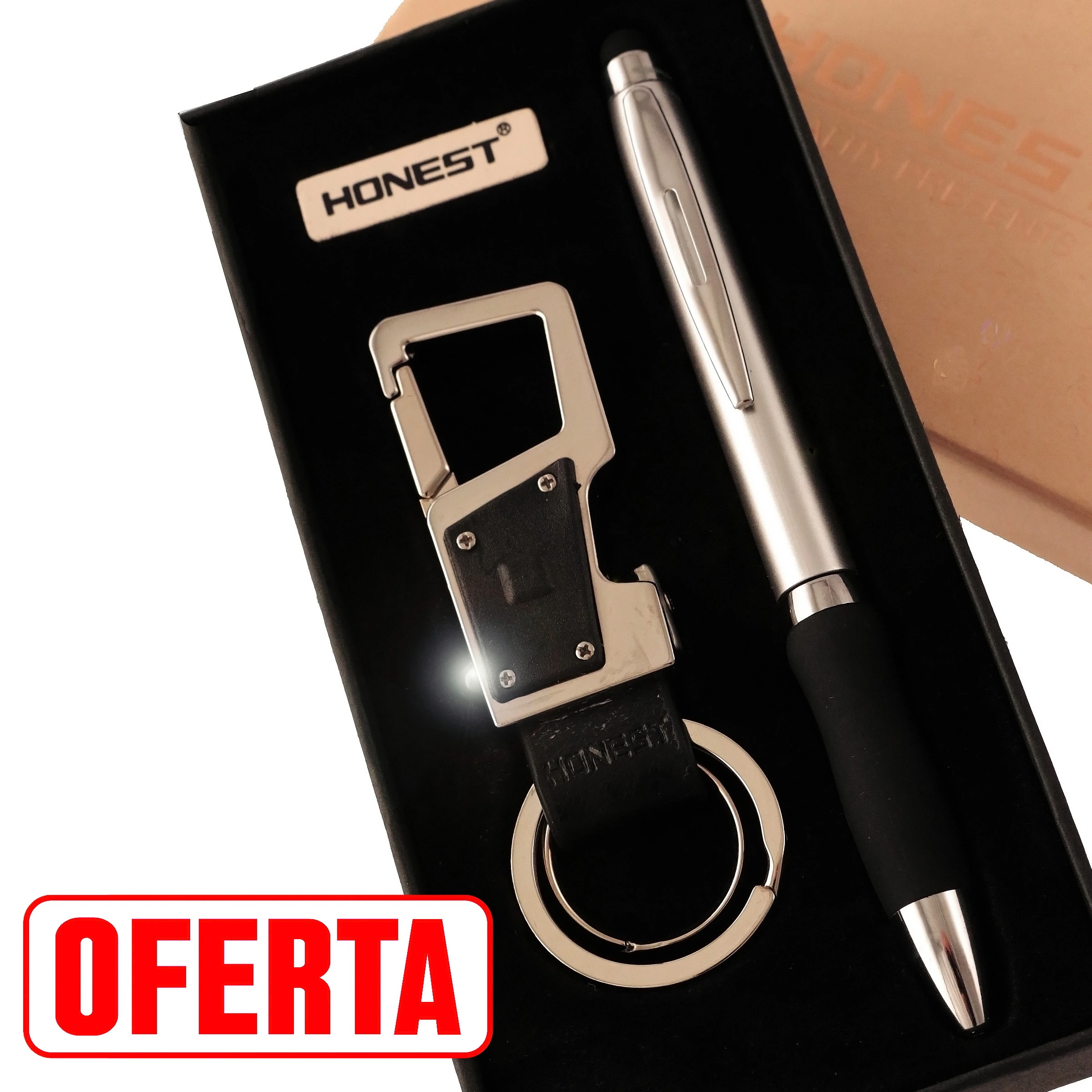 Estuche negro abierto de Honest con bolígrafo plateado de agarre negro y llavero con mosquetón, pieza rectangular y anilla.