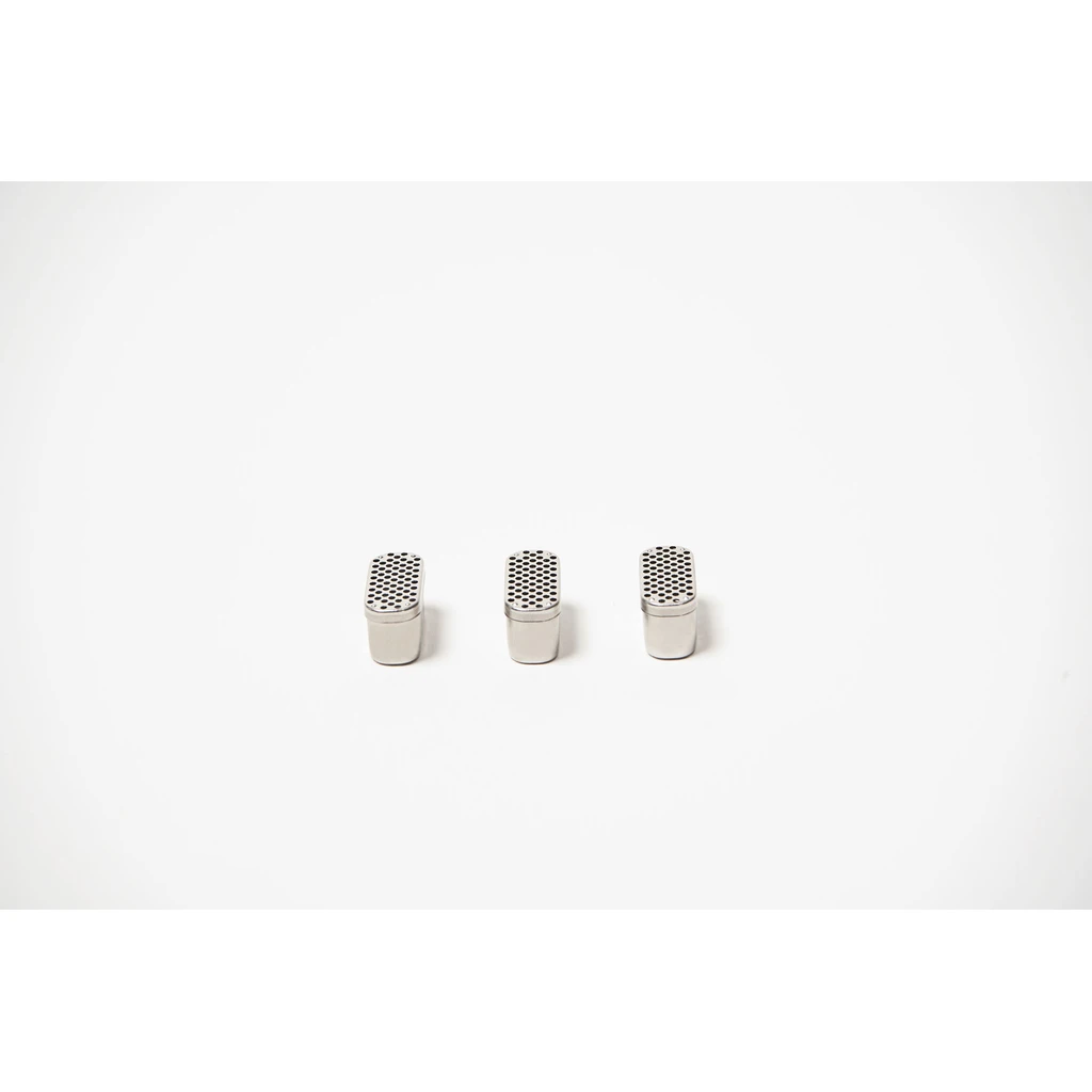 Tres cápsulas BudKups plateadas, alineadas sobre fondo blanco, con cuerpo alargado y tapas perforadas.