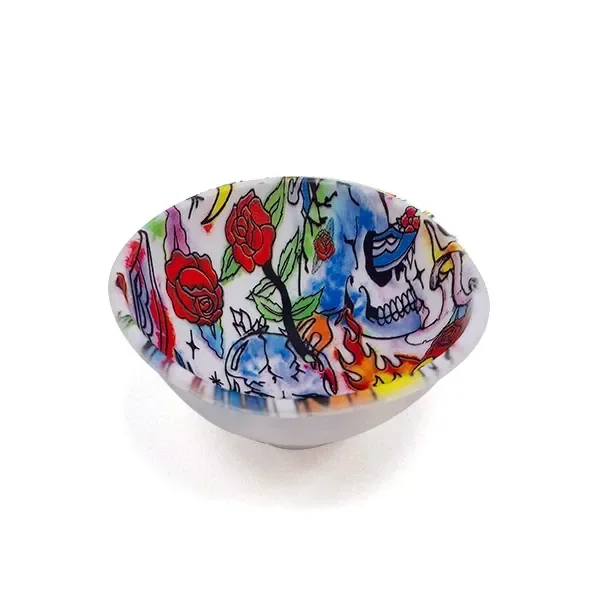 Cuenco visto en perspectiva, con exterior blanco e interior decorado con calaveras, rosas rojas y llamas multicolores. Cuenco visto en perspectiva, con exterior blanco e interior decorado con calaveras, rosas rojas y llamas multicolores.