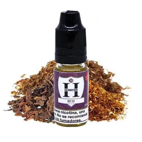 Frasco de Herrera Salts Boj con tapón negro y etiqueta morada y blanca, situado delante de montones de hojas de tabaco troceadas.