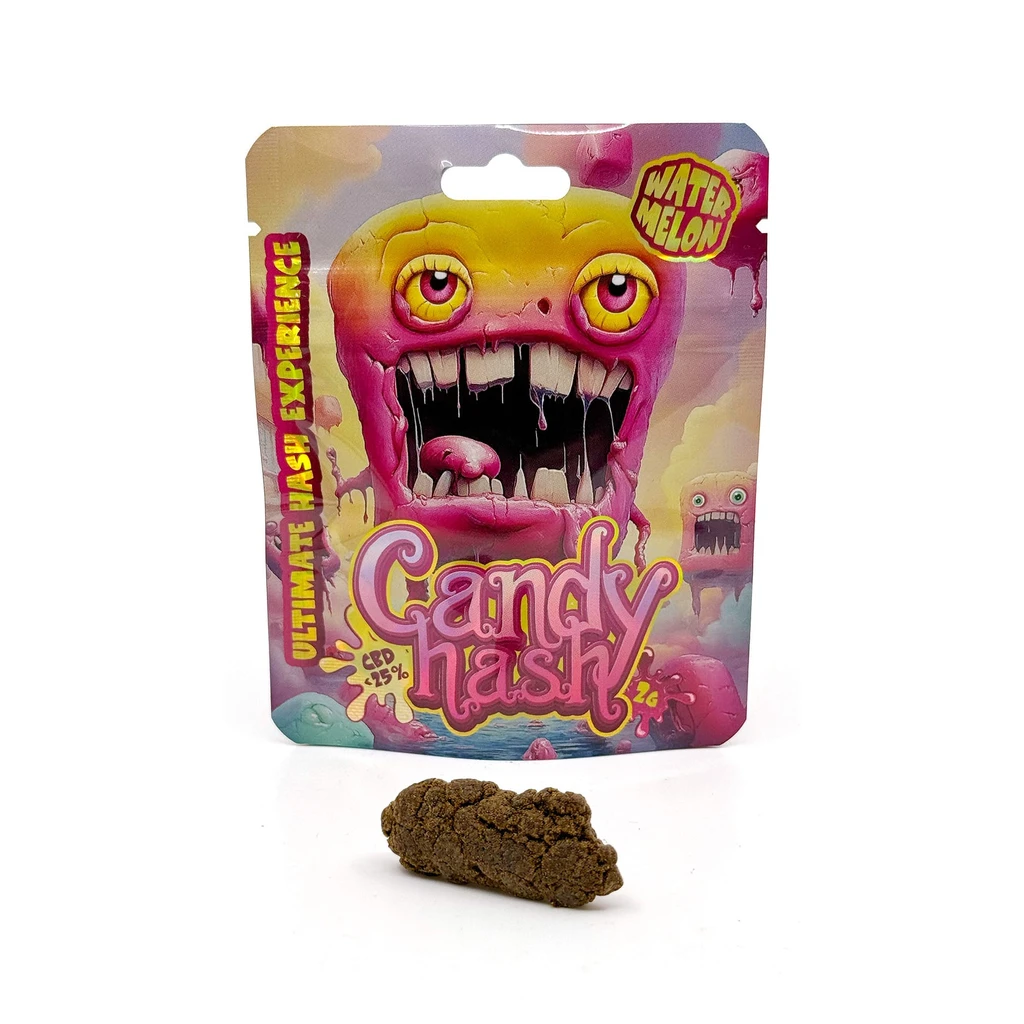 Candy Hash Watermelon CBD en bolsa con un monstruo rosa y amarillo, junto a una pieza marrón de superficie irregular sobre fondo blanco.