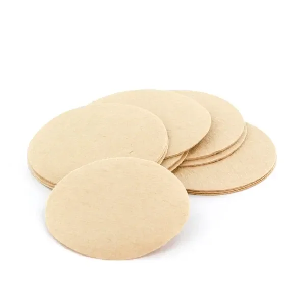Varios filtros circulares planos de color beige, superpuestos sobre fondo blanco, con uno separado en primer plano.