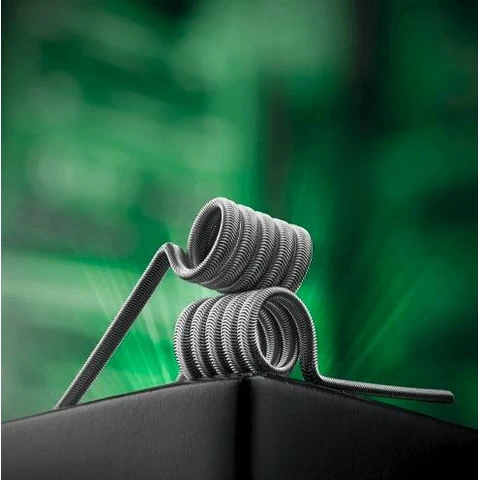 Resistencias Charrocoils The Forge Xenomorph de hilo enrollado, apiladas sobre una base negra con fondo verde desenfocado.