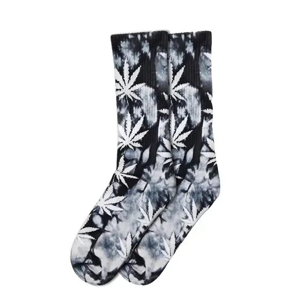 Calcetines de caña alta con fondo jaspeado negro y gris y grandes hojas de cannabis blancas, sobre fondo blanco.