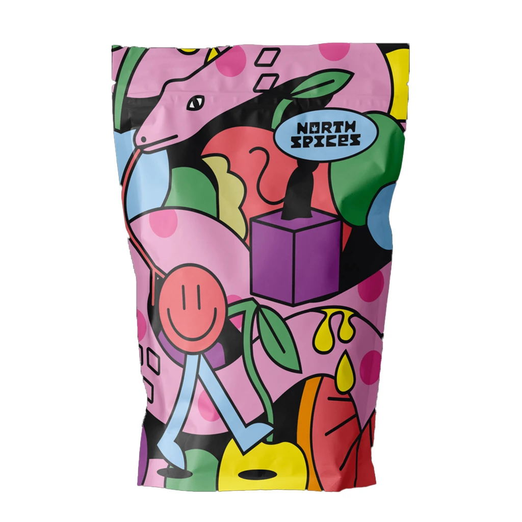 Bolsa de North Spices con fondo rosa y dibujos de una serpiente, hojas verdes, un cubo morado y una cara sonriente.