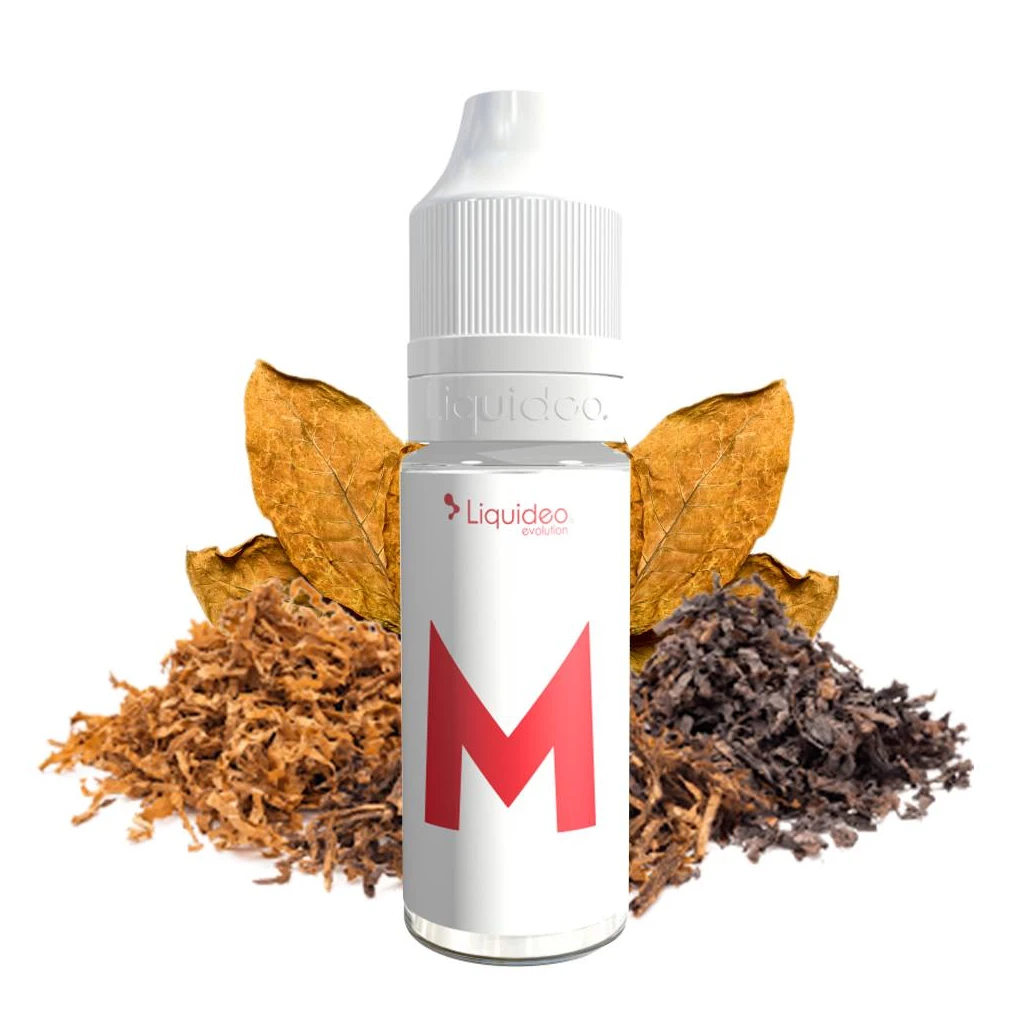Frasco Le M Evolution de Liquideo con tapón blanco y una gran M roja en la etiqueta, delante de hojas y montones de tabaco.