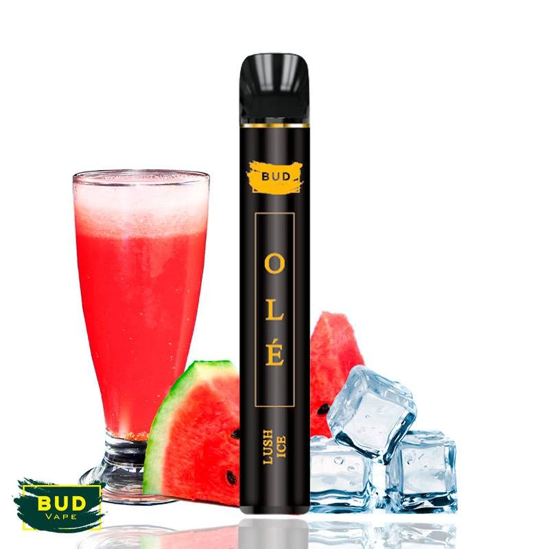 Pod Lush Ice Olé de Bud Vape, negro con letras doradas, junto a un vaso de bebida roja, trozos de sandía y cubitos de hielo.